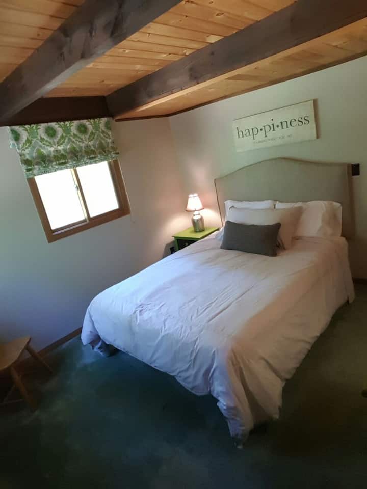 Cama Queen Size (andar principal) com cômoda e armário.