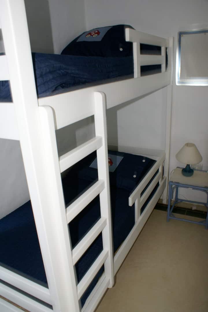 Chambre d'enfant avec quatre lits.