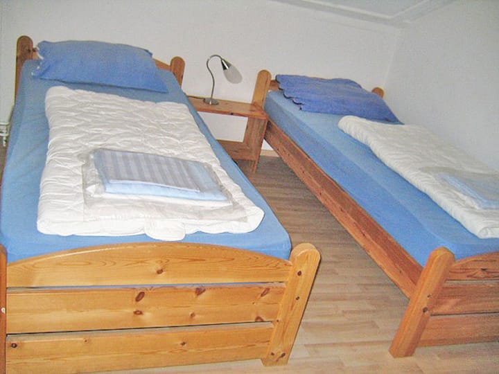 חדר שינה עם 2 מיטות יחיד למעלה.