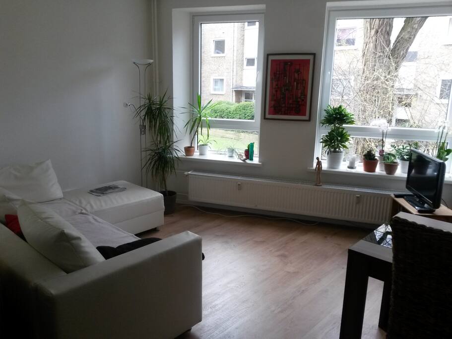 Wohnzimmer mit Sofa und großer Fensterfront