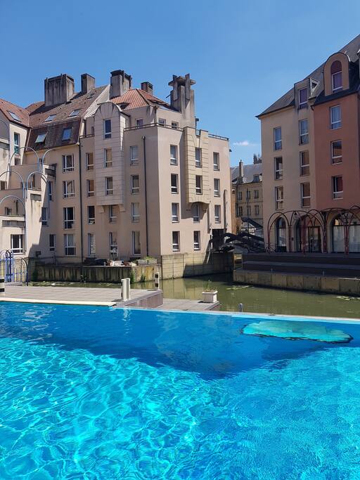 Vue de la piscine extérieure et du ponton en bois pour accéder à la Suite