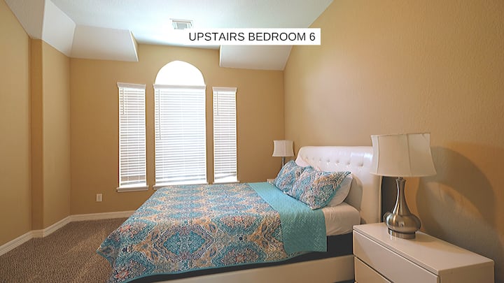 Cama queen en un dormitorio de arriba.