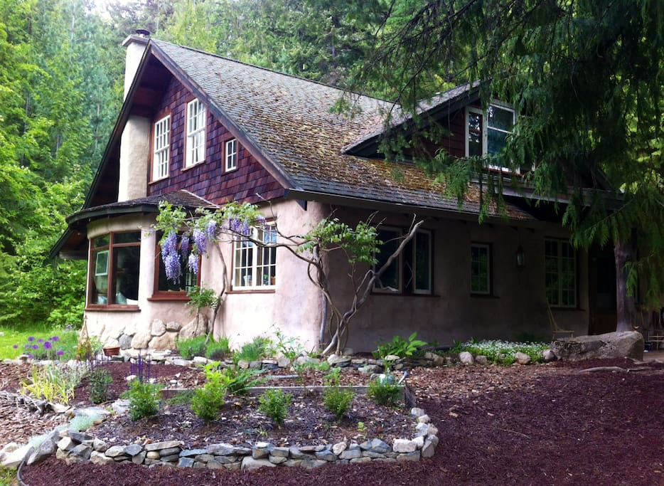 A rustic whimsical straw-bale cottage at the edge of the forest