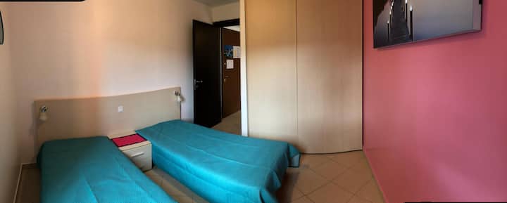Spavaća soba s dva kreveta za jednu osobu i ormarima za odlaganje.