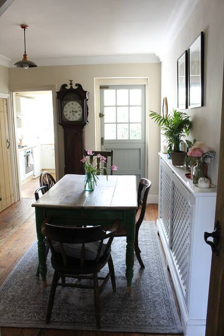 Dining room with open fireplace, wooden floor boards, seating for 6, and back door out to garden