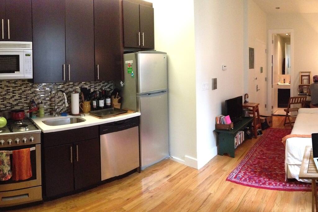 Great shot of the living room and kitchen. High, lofted ceilings and new hardwood floors.
