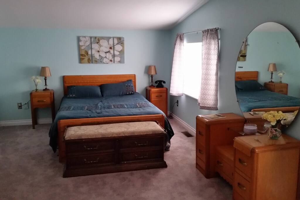 Sleeping area with queen bed and dresser