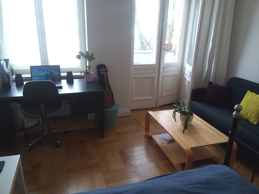 Sofa area, balcony and comuter desk.