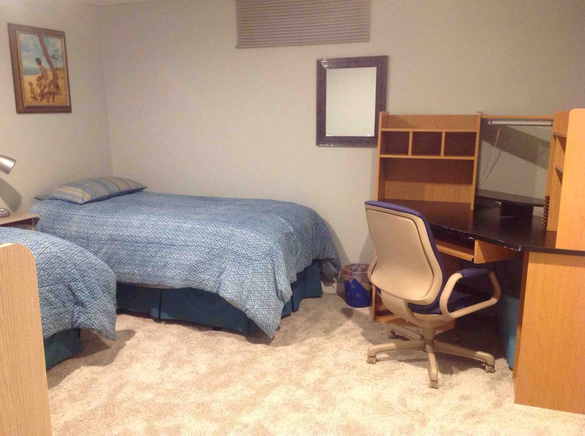 Segundo dormitorio con dos camas individuales y escritorio