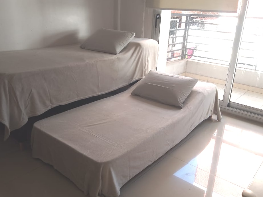 Sillón cama en living dispuesto como dos camas individuales.