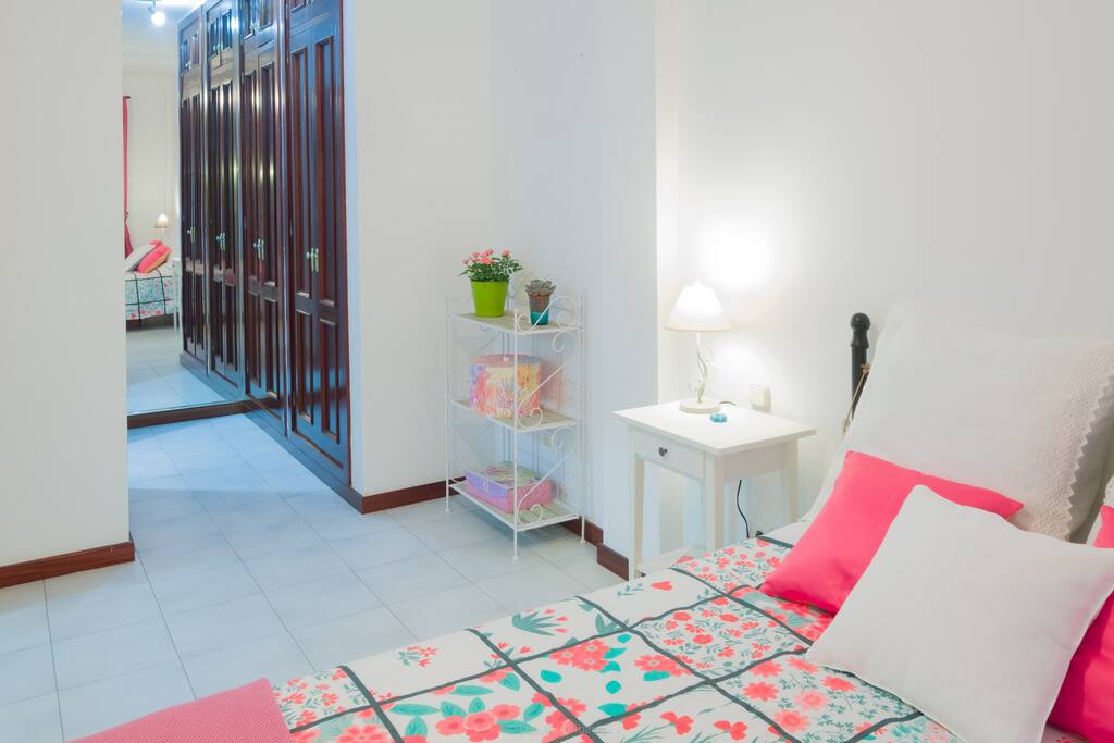 Dormitorio cama 135x180 con ventilador de techo y pequeño balcón