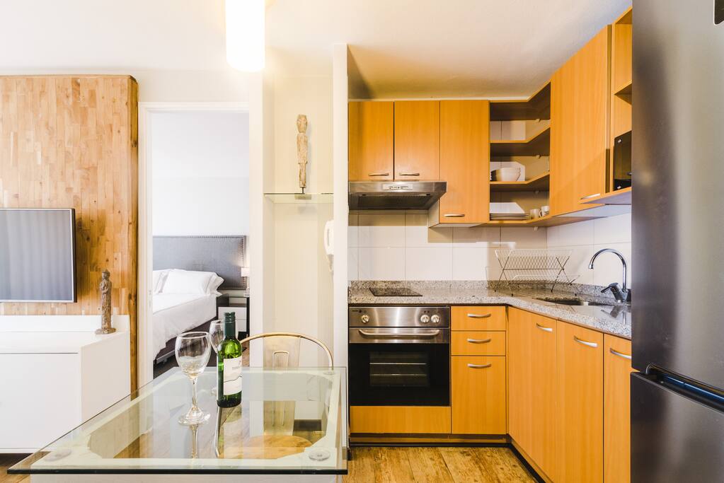 The kitchen opens directly to the living room and has a dining table/workspace.