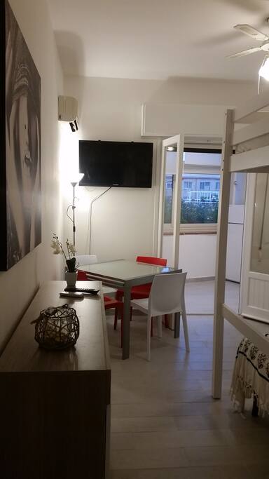 Monolocale con tv pale a soffitto e aria condizionata.