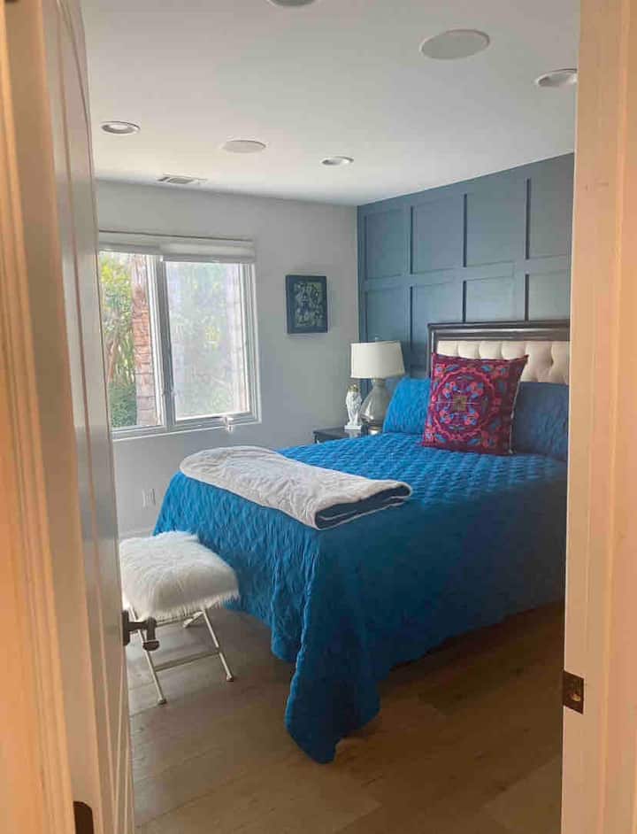 Cama tamaño queen , TV de 60 pulgadas. Dormitorio con baño adyacente.