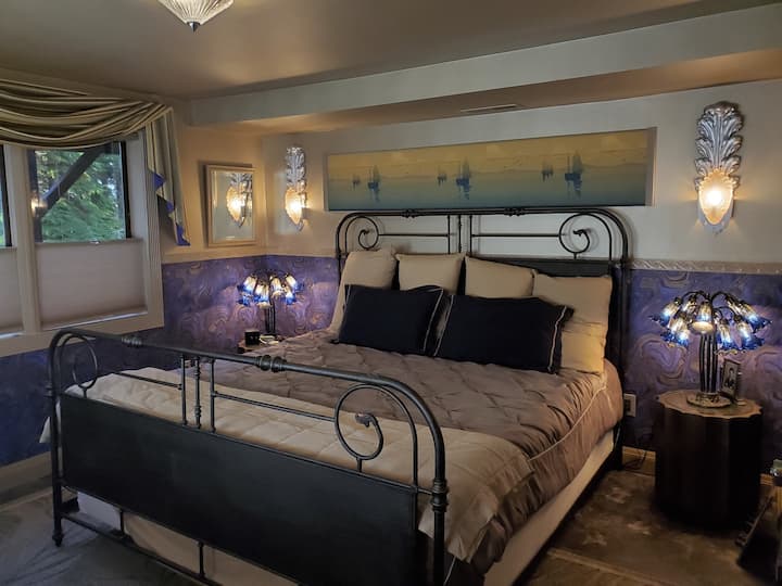 The master bedroom offers a unique violet-gold theme with custom Deco sconces designed by your host.