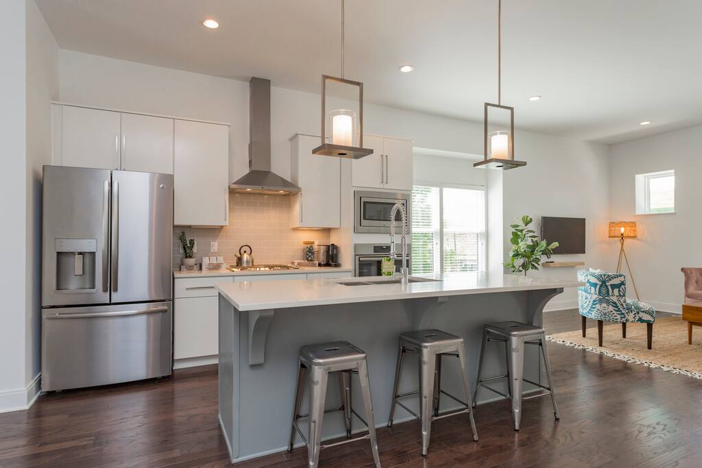 Main Level: Open kitchen with bar seating leading to dining area.