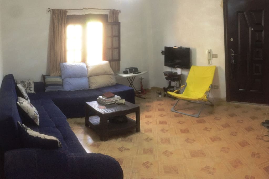 Shared living room with comfortable sofa and TV with Nilesat channels.