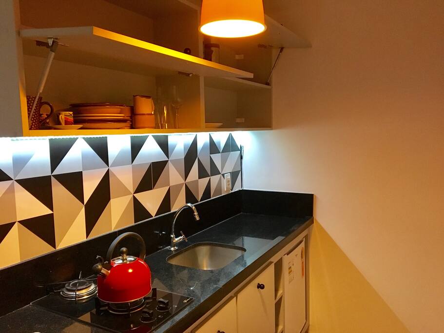 Cozinha equipada com fogão, microondas, torradeira, cafeteira e frigobar.