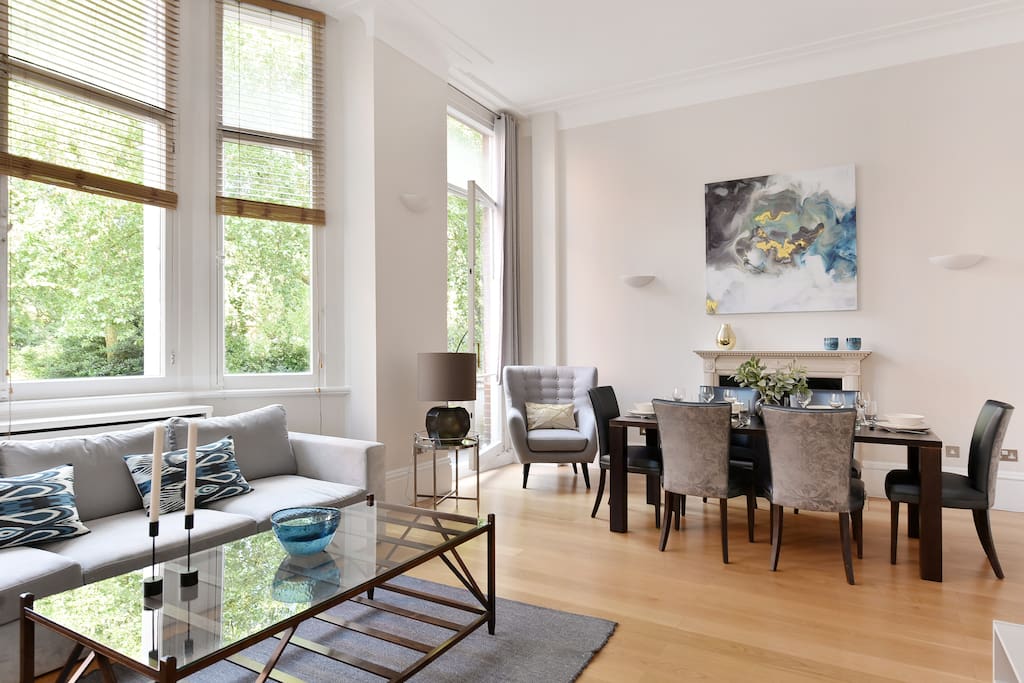 The spacious, bright and elegant Lounge and dining area with TV and balcony overlooking the gardens
