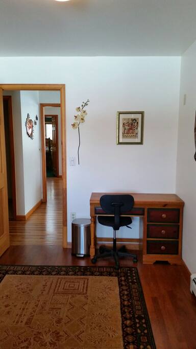 Desk by doorway in bedroom.