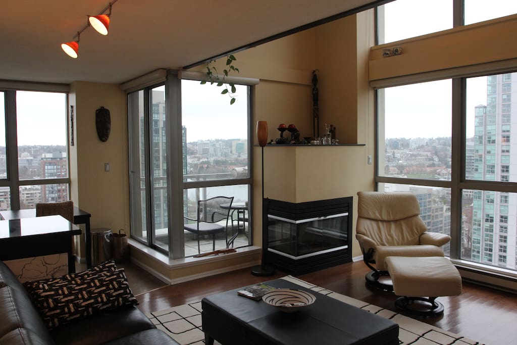 Another view of the living room; there's a small balcony with two chairs, a table, and a gas grill.