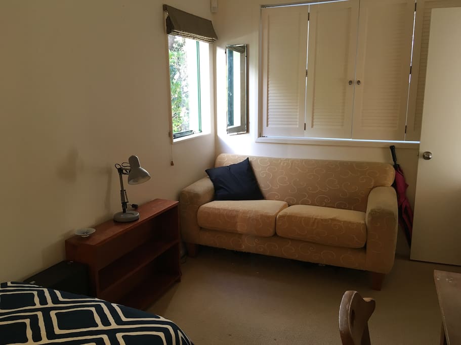 Single bedroom with desk and sofa, sunny in the evenings.