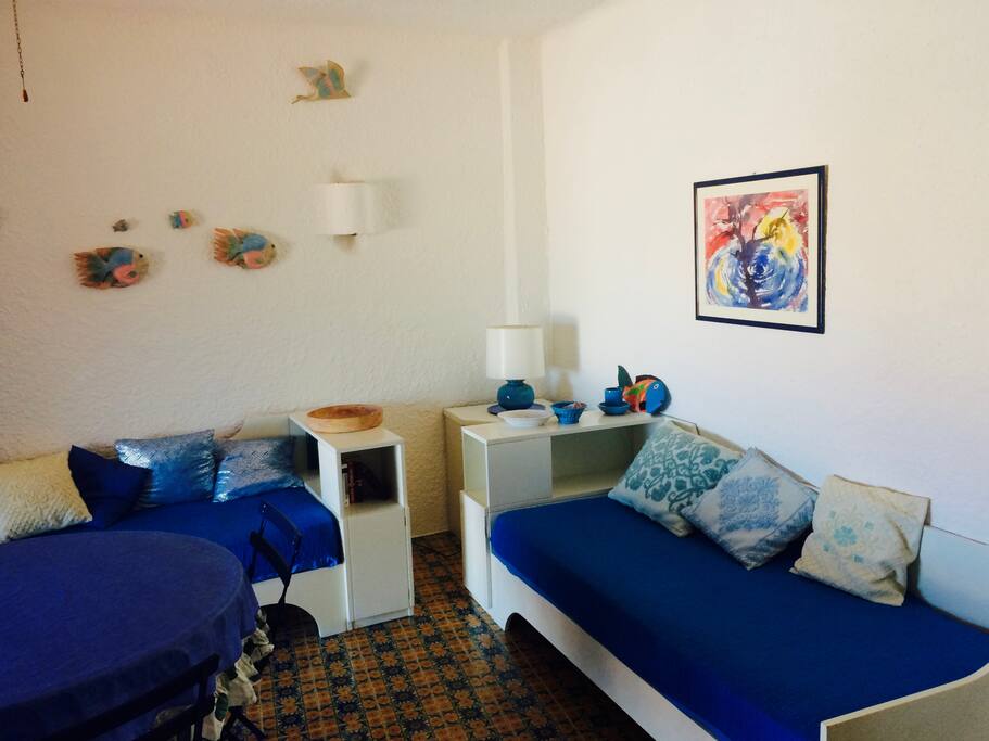 Soggiorno con due divano-letto, televisione e tavolo da pranzo.
- Living room with two sofa-beds, tv and dining table available.