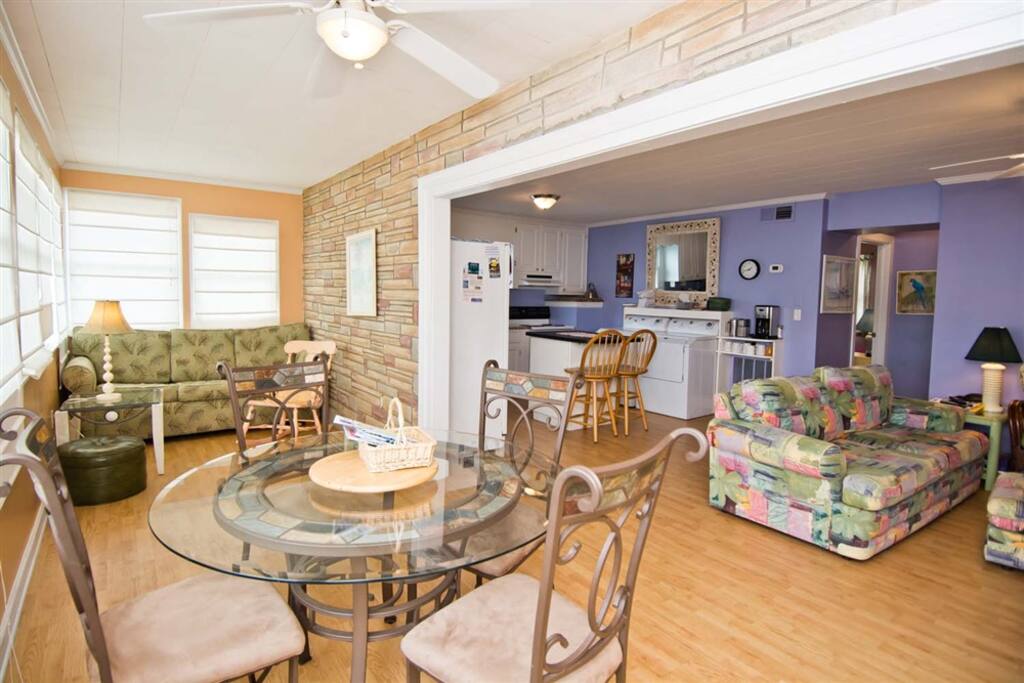 Sunroom with dining room table adjacent to livingroom & kitchen