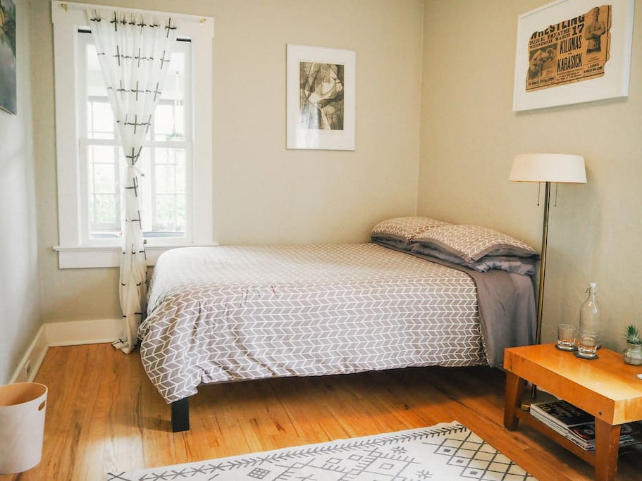Clean and cozy private bedroom with full bed, lots of light, a closet, and an adjacent semi-private bathroom.