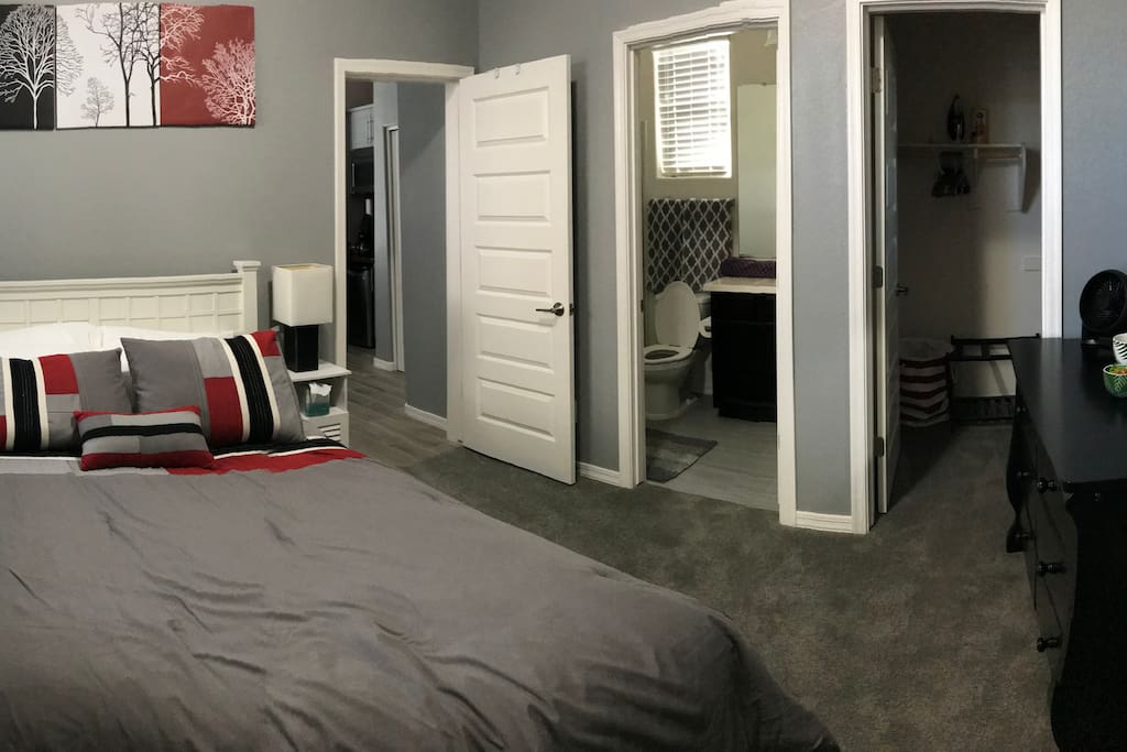 Bedroom with queen bed, nightstands, dresser, walk in closet and full bathroom