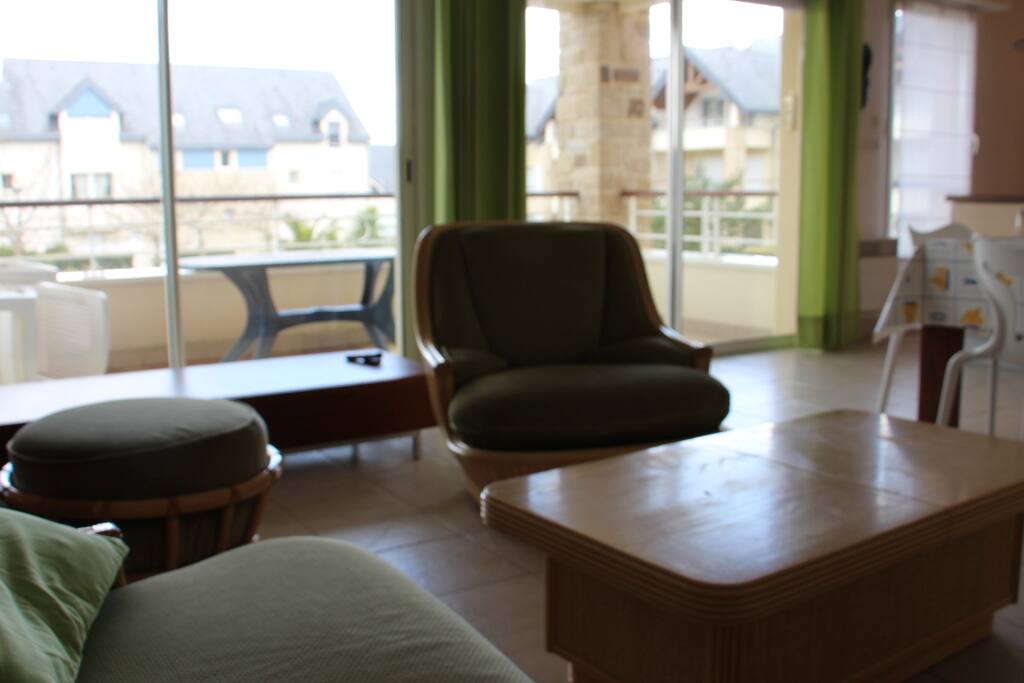 Une double baie vitrée sur toute la longueur du salon donnant sur une grande terasse couverte, sur le jardin intérieur.