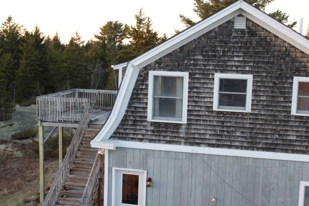A view of the stairs to the deck and side of the house