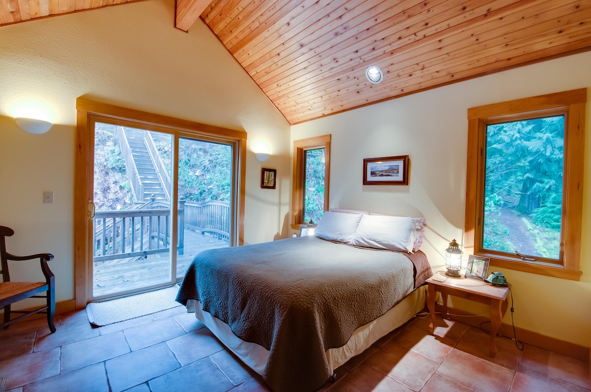 Una magnífica suite de dormitorio principal con techos abovedados de cedro, balcón con puente a terrazas superiores.