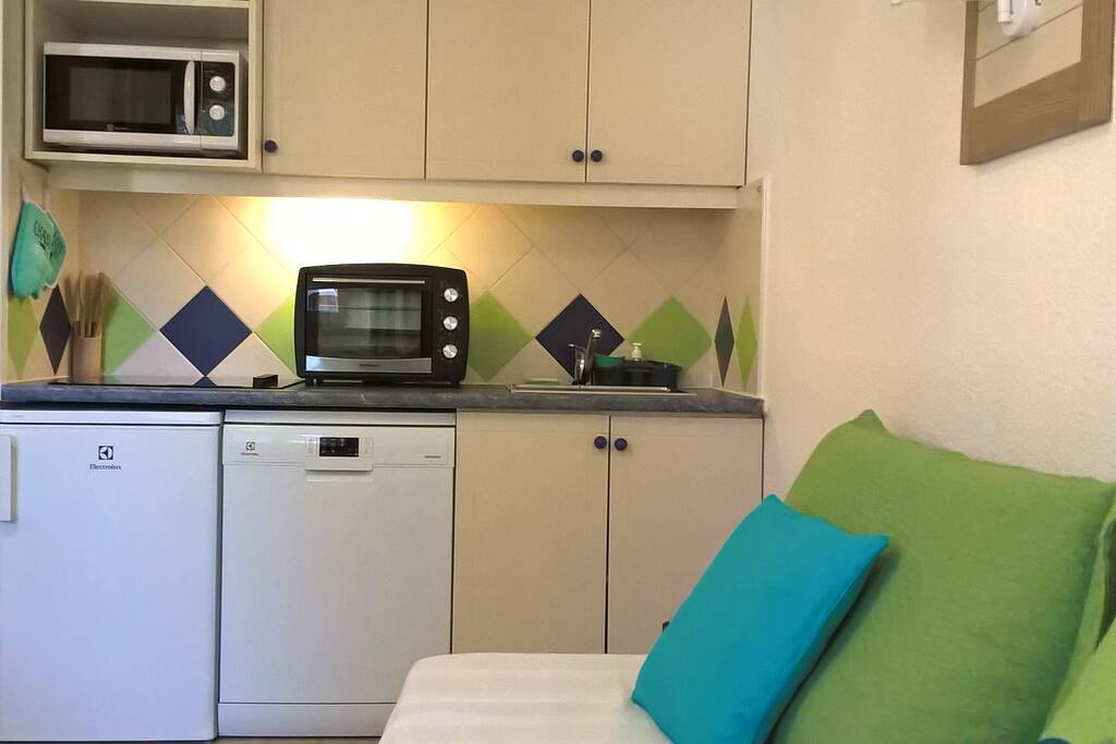 Une cuisine entièrement équipée ouverte sur le séjour : plaque de cuisson à induction 4 foyers, un four, un micro-ondes, un lave vaisselle, un frigo, un grille pain, une bouilloire, une machine à café, poêles, casseroles et plats divers, ustensiles de cuisine et vaisselle (pour 6 pers).