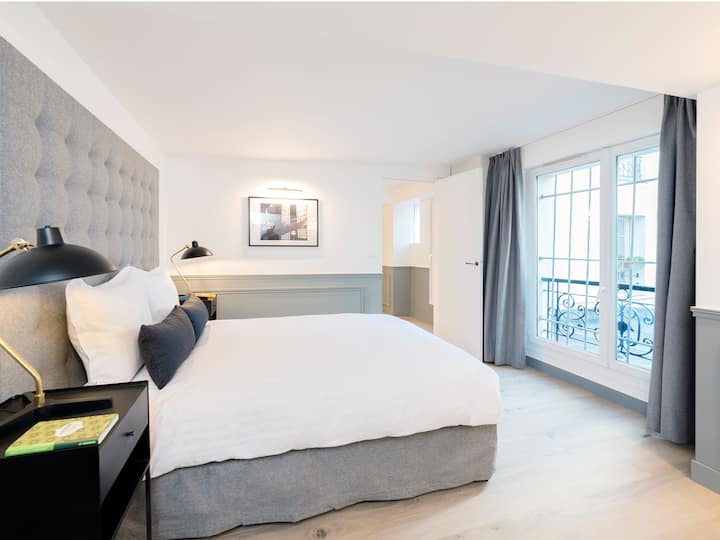 EN : First bedroom with double bed, linen and view over the courtyard / 
FR: First bedroom with a double bed, bedding and views of a quiet courtyard
