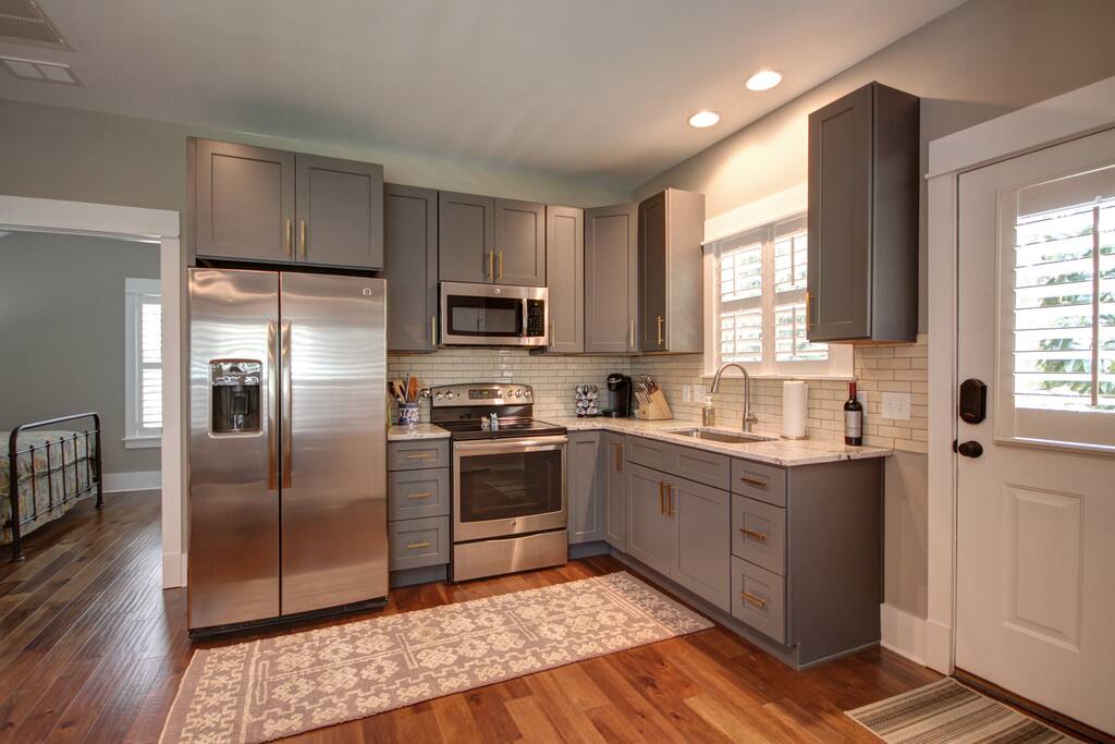 Full kitchen stocked with dishes, pots, pans, cooking utensils, and coffee machine.