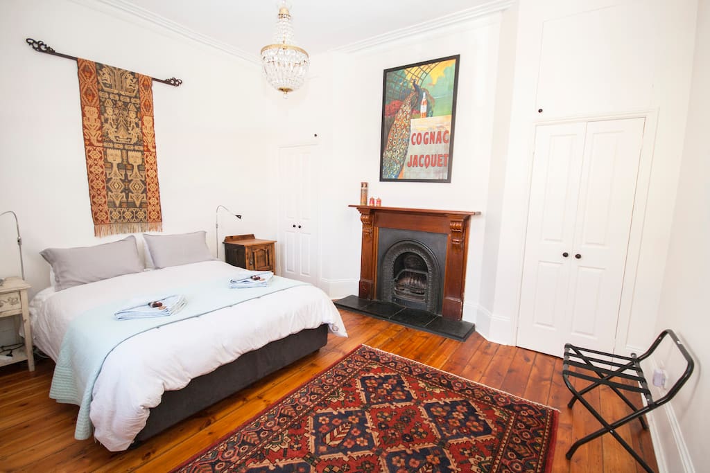 Large, light-filled bedroom with build in robes and fireplace
