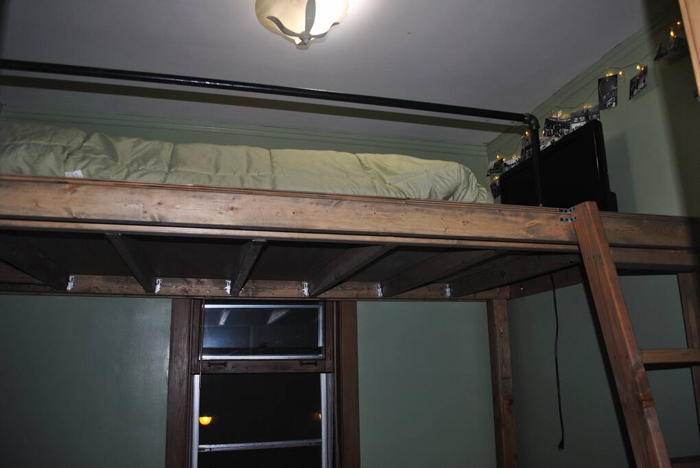 Spacious loft bed with a TV.