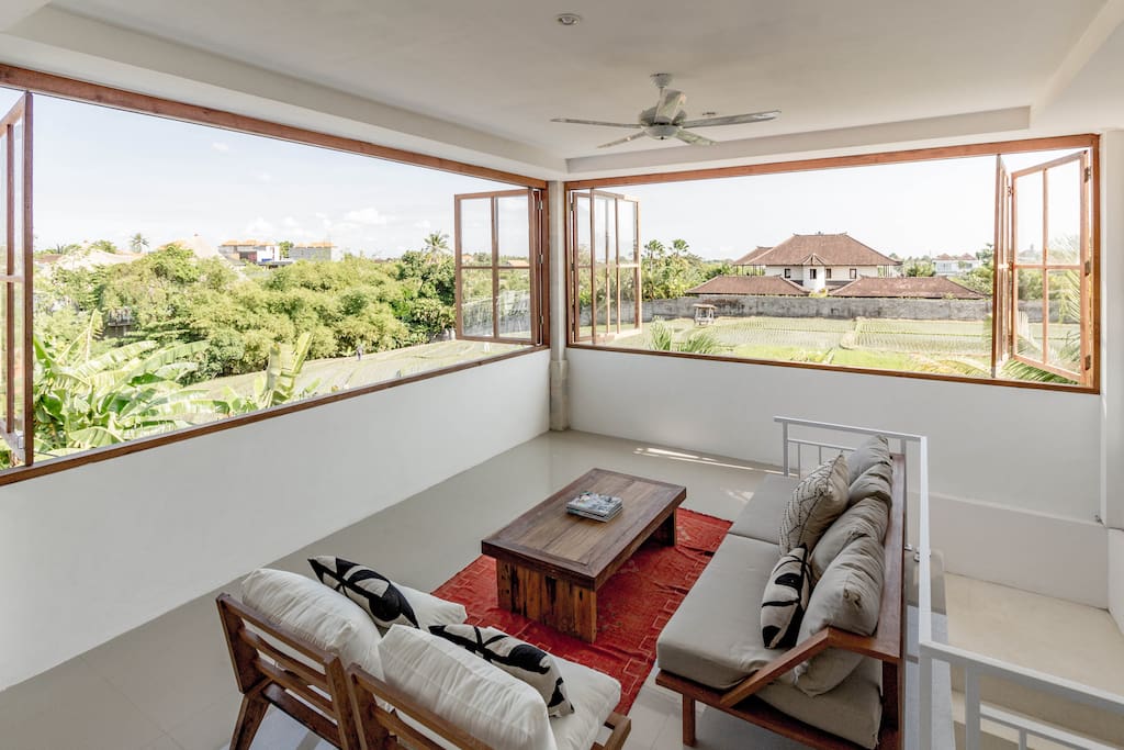 Upstairs living room with massive windows and view of rice fields