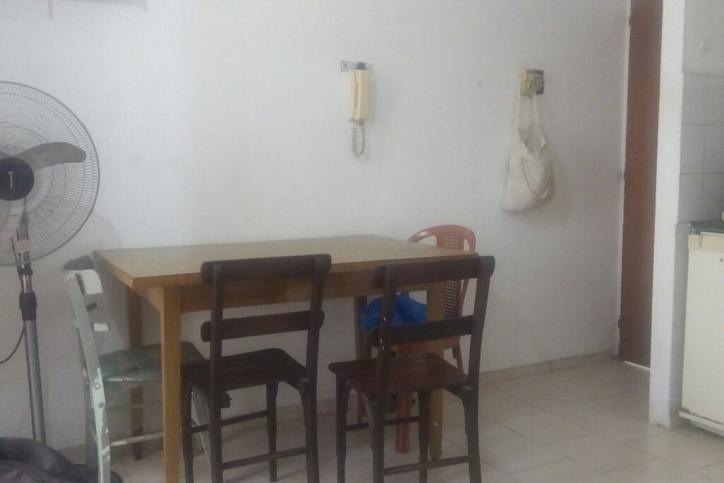 mesa amplia con cuatro sillas y ventilador