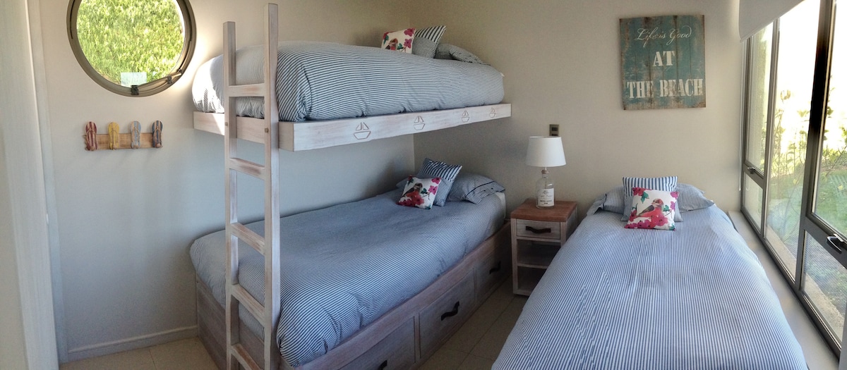 Dormitorio 2 con 3 camas individuales y vista al mar