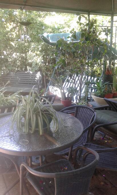 terraza con silla balancin, y sillones y mesa con 6 sillas y dos sillones.