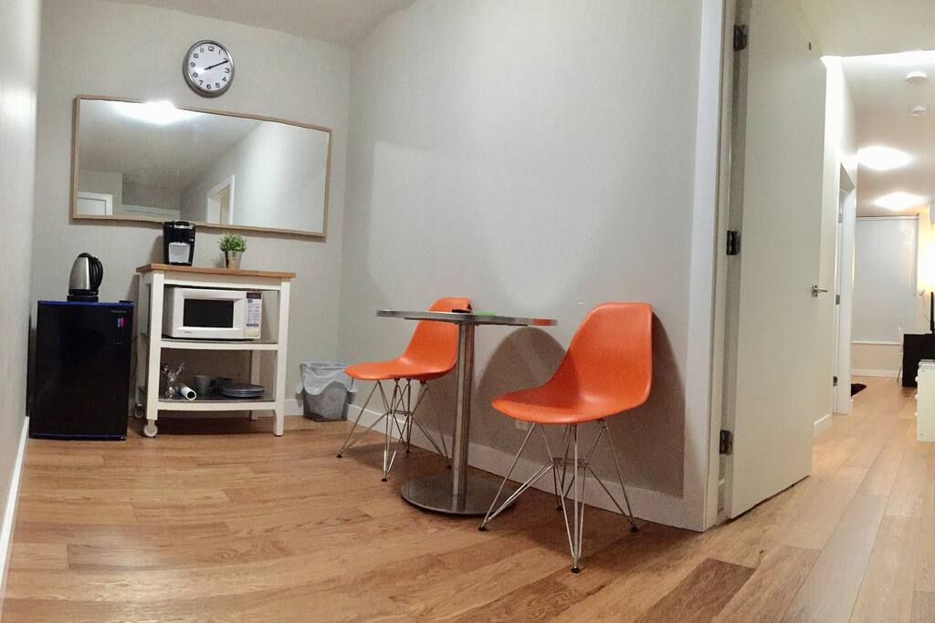 Den/entrance area with dining table and newly added microwave and mini fridge.