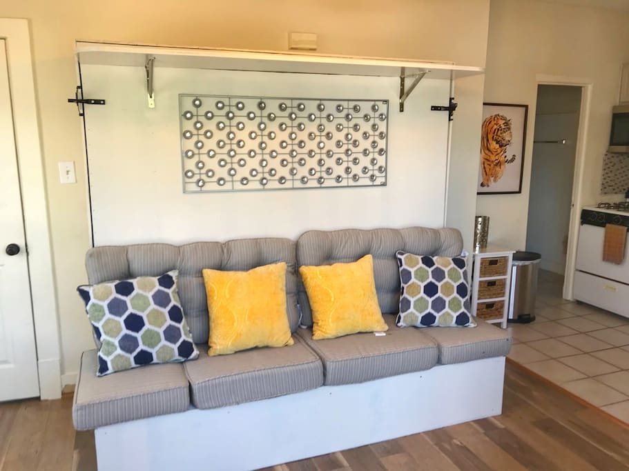 The sofa opens up to a full size queen bed that is mounted to the wall