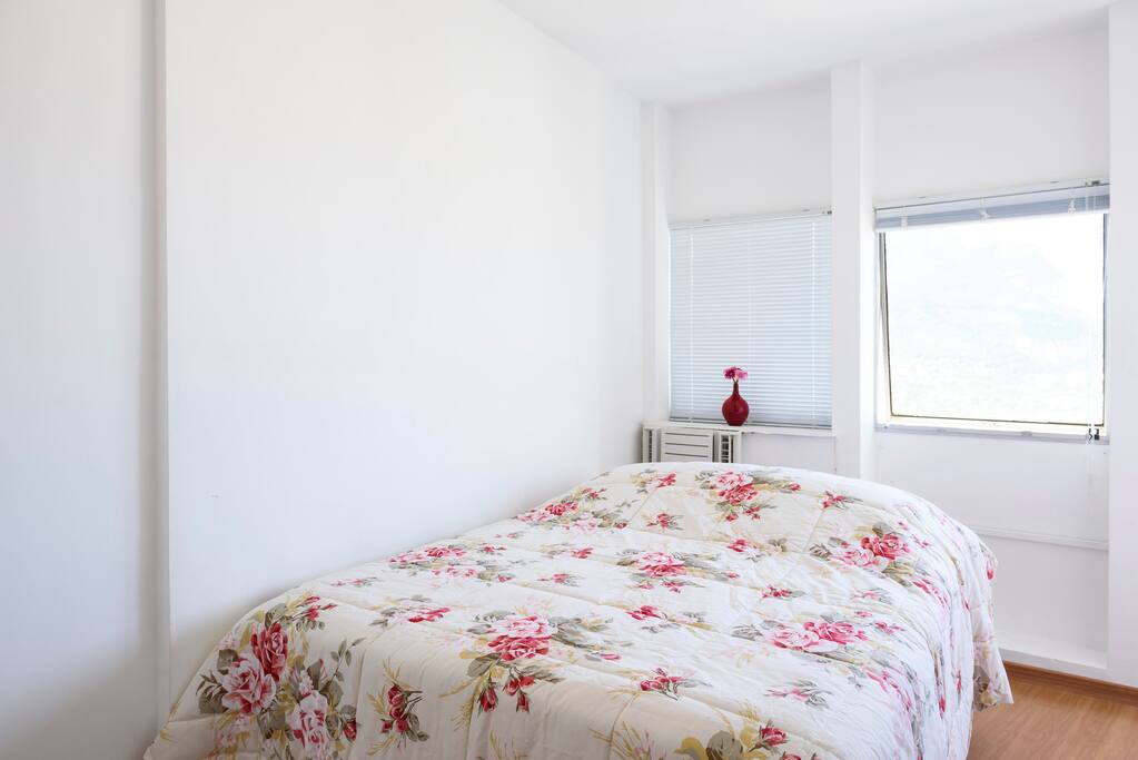 Suíte com ar-condicionado, cama de casal, poltrona e armário.