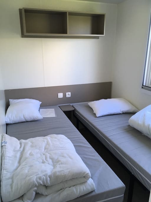 Deux chambres avec des lits simples