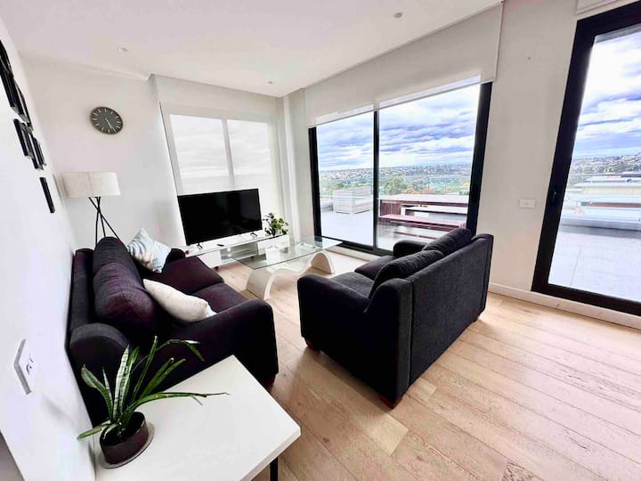 אזור טרקלין עם שתי ספות וטלוויזיה חכמה סמסונג 55אינץ 'המשקיפה על המרפסת עם נוף פנורמי