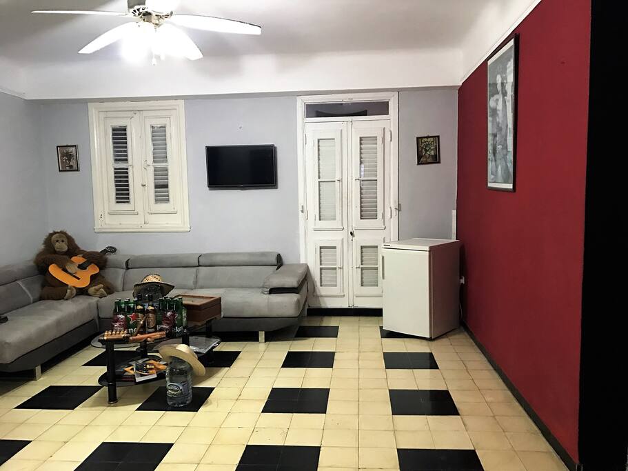 Living-room with a comfortable couch, a bar, Tv 32'' and fridge.