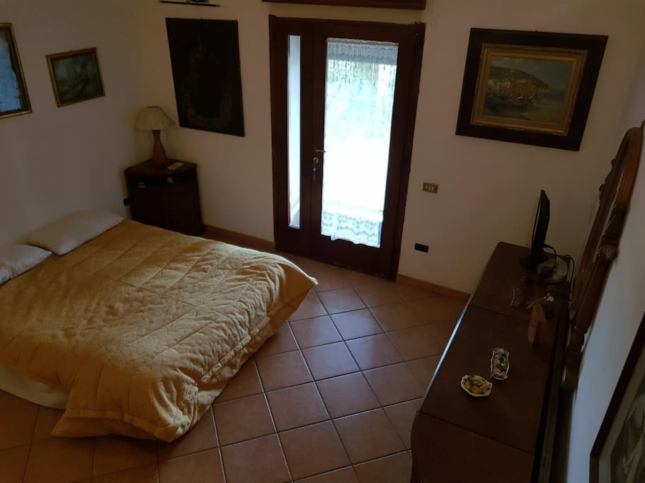 camera da letto con porta sul porticato/terrazza
