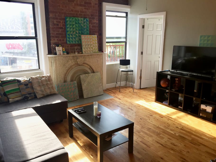 Relax in our sunny, airy, comfortable living room with exposed brick walls, vintage marble, wood floors and tons of sunlight.